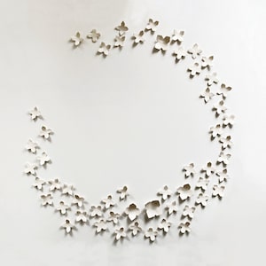 Original ceramic wall art set of geometric flowers. There are 60 pieces in total arranged in a loosely circular shape. Each piece is made by hand here in my studio.
