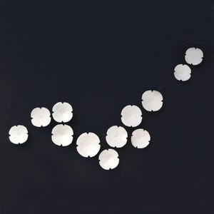Organic arrangement of ceramic flowers. They are positioned in an organic flowing V shape and the set in this picture has more pieces than listed but it is to demonstrate how a set would look with more pieces