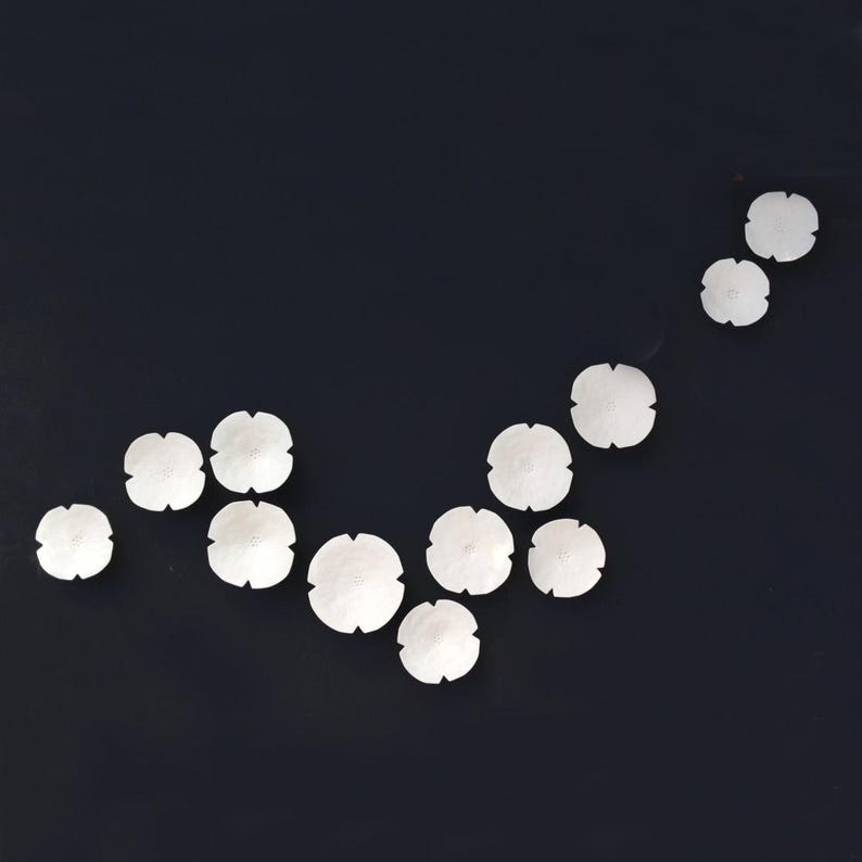 Organic arrangement of ceramic flowers. They are positioned in an organic flowing V shape and the set in this picture has more pieces than listed but it is to demonstrate how a set would look with more pieces