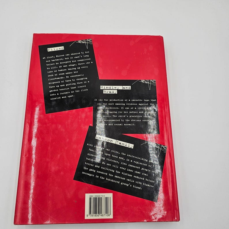 May include: A red book with black text and white text blocks. The text blocks contain excerpts about crime and violence. The book's title is not visible. The book has a barcode on the bottom left corner.