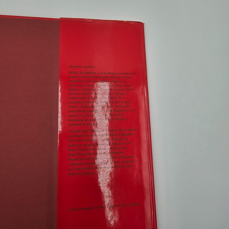 May include: A close-up of a book's spine and back cover, predominantly red with white text. The text includes "About the Authors" and biographical information about Nigel Blundell and Susan Blackhall, both journalists and authors.
