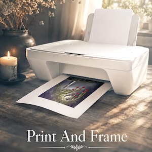 Puede incluir: Una impresora de inyecci&oacute;n de tinta blanca con una hoja de papel saliendo de la bandeja frontal, mostrando una ilustraci&oacute;n colorida de setas rojas y un bosque oscuro. El texto Print And Frame for Dreamy Decor est&aacute; centrado abajo.
