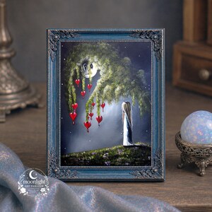 Puede incluir: Una pintura enmarcada en un marco azul oscuro ornamentado que muestra una figura de pie sobre una colina cubierta de hierba bajo un gran &aacute;rbol con adornos rojos en forma de coraz&oacute;n. La escena se desarrolla bajo un cielo nocturno con luna.