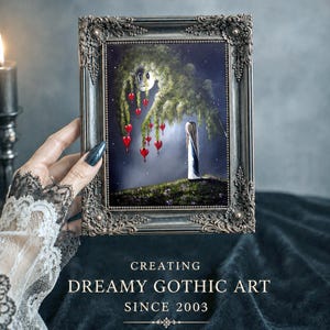 Puede incluir: Una pintura enmarcada en un marco met&aacute;lico oscuro y ornamentado que muestra una figura de pie sobre una colina cubierta de hierba bajo un gran &aacute;rbol llor&oacute;n con adornos rojos en forma de coraz&oacute;n. El texto dice: CREATING DREAMY GOTHIC ART SINCE 2003.
