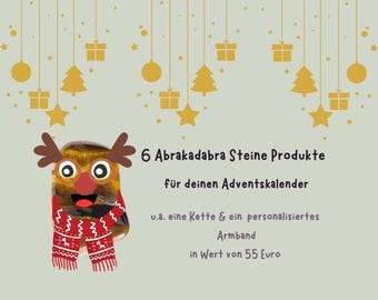 Może przedstawiać: Kamień tygrysie oko ozdobiony brązowymi rogami renifera, czerwonym nosem oraz czerwono-białym szalikiem we wzory. Tekst głosi: 6 Abrakadabra Steine Produkte für deinen Adventskalender u.a. eine Kette & ein personalisiertes Armband in Wert von 55 Euro.