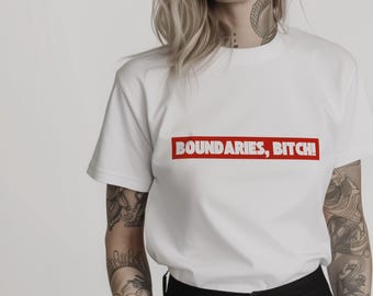 May include: White t-shirt with the text "BOUNDARIES, BITCH!" in a red rectangular box. The shirt has short sleeves and a crew neck. The text is in a bold, sans-serif font.