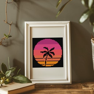May include: A framed print of a retro sunset with a palm tree in the center. The sunset is a gradient of pink, orange, and yellow. The palm tree is black.