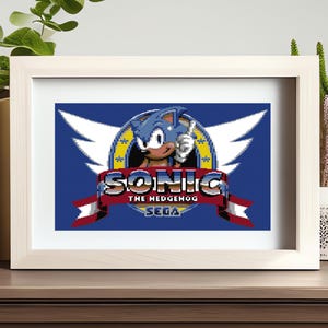 May include: A blue and red pixelated logo for the video game Sonic the Hedgehog. The logo features Sonic the Hedgehog with a blue and white background and the text "Sonic the Hedgehog" and "SEGA".