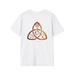 Può includere: Una t-shirt bianca a maniche corte con un simbolo triquetra sul retro. Il simbolo contiene una croce, un globo, una colomba e un calice con una sfumatura arancione e marrone. Il testo Matthew 28:19 è stampato in arancione sotto la grafica.
