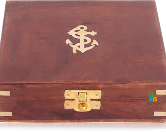 May include: A rectangular dark brown wooden box featuring a polished brass anchor inlay on the lid. The box is secured with a central brass latch and includes brass corner accents on the front panel, providing a sturdy and functional storage container.