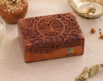May include: A rectangular wooden box with a dark brown finish featuring an intricate carved tree of life design on the lid. The front side of the box displays the text Craft Cooper in a simple black font. The box has a smooth, polished surface.