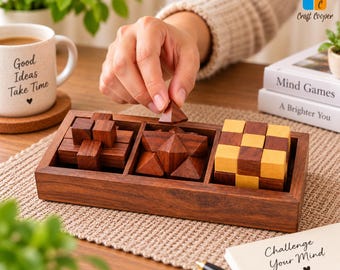 May include: A rectangular wooden tray containing three distinct wooden brain teaser puzzles. The left puzzle is a dark wood interlocking cross, the center is a star-shaped puzzle, and the right is a cube with alternating light and dark wood blocks.