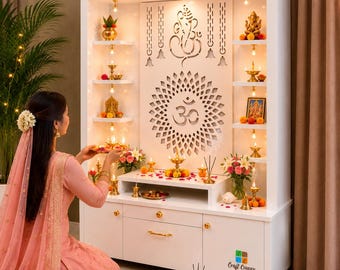 May include: A white wooden home temple unit featuring a central panel with a laser-cut Om symbol and Ganesha motif. The structure includes multiple shelves illuminated by small lights, holding brass oil lamps, figurines, and floral arrangements.