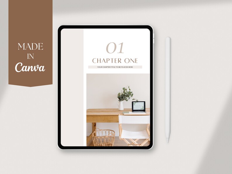 May include: A digital tablet displaying a chapter one page of a digital planner. The page is white with brown text that reads "01 Chapter One" and "Your chapter title to be placed here". The background image is a photo of a wooden desk with a laptop, a white chair, a vase with greenery, and a wicker basket.