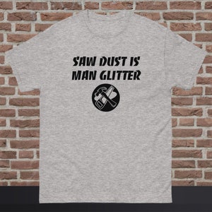 May include: Gray t-shirt with the text "Saw Dust Is Man Glitter" and a black and white illustration of a hammer and saw in a circle.