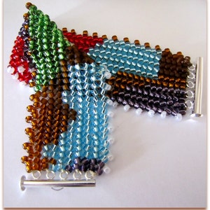 May include: A colorful beaded bracelet with a geometric design. The bracelet features a variety of colors, including red, green, blue, brown, and purple. It has a silver-tone clasp and is made of small, evenly spaced beads.