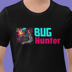 Könnte beinhalten: Schwarzes T-Shirt mit einem Grafikdruck einer Person mit einem Raumhelm, die eine Tastatur hält. Der Text "BUG Hunter" ist in Pink und Blau gedruckt.