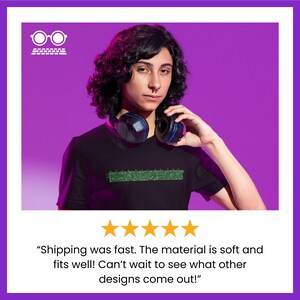Może przedstawiać: Osoba w czarnym t-shircie z zielonym pikselowym wzorem i słuchawkami na szyi. Tło jest fioletowe. Tekst "Shipping was fast. The material is soft and fits well! Can't wait to see what other designs come out!" znajduje się pod obrazkiem.