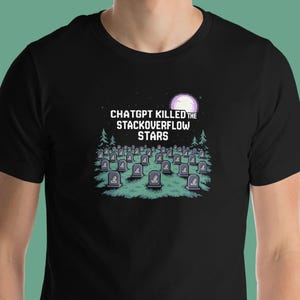 Könnte beinhalten: Schwarzes T-Shirt mit einem grafischen Design, das eine Friedhofsszene unter einem Vollmond zeigt. Der Text "ChatGPT Killed the StackOverflow Stars" ist über dem Friedhof aufgedruckt, der viele Grabsteine ​​hat.
