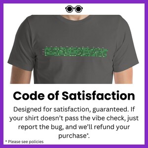 Może przedstawiać: Szary t-shirt z zielonym pikselowym wzorem i nadrukiem "Code of Satisfaction" z przodu. Tekst pod wzorem brzmi "Designed for satisfaction, guaranteed. If your shirt doesn't pass the vibe check, just report the bug, and we'll refund your purchase.*". Tekst na dole brzmi "*Sprawdź zasady*".