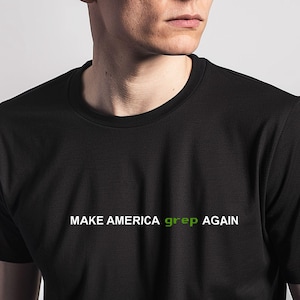 May include: A black t-shirt with the text "MAKE AMERICA grep AGAIN" in white and green lettering.