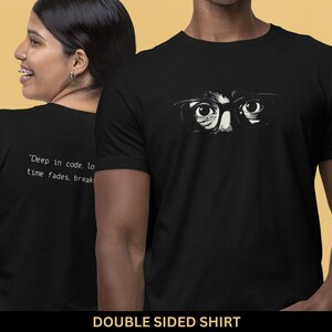 Może przedstawiać: Czarny dwustronny t-shirt z białym nadrukiem osoby w okularach po jednej stronie i tekstem "Deep in code, lost in time fades, break" po drugiej.