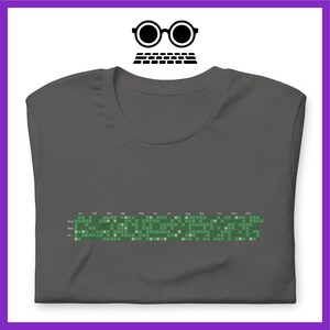 Może przedstawiać: Ciemnoszary t-shirt z zielonym pikselowym wzorem kalendarza. Kalendarz pokazuje dni tygodnia i miesiące roku.