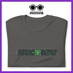 Peut inclure: T-shirt gris fonc&eacute; avec un graphique pixelis&eacute; vert d'une personne. Le graphique est un calendrier avec les jours de la semaine et les mois de l'ann&eacute;e &eacute;tiquet&eacute;s.