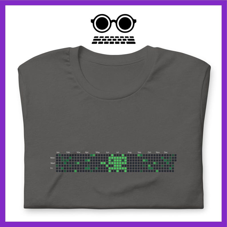 Peut inclure: T-shirt gris fonc&eacute; avec un graphique pixelis&eacute; vert d'une personne. Le graphique est un calendrier avec les jours de la semaine et les mois de l'ann&eacute;e &eacute;tiquet&eacute;s.