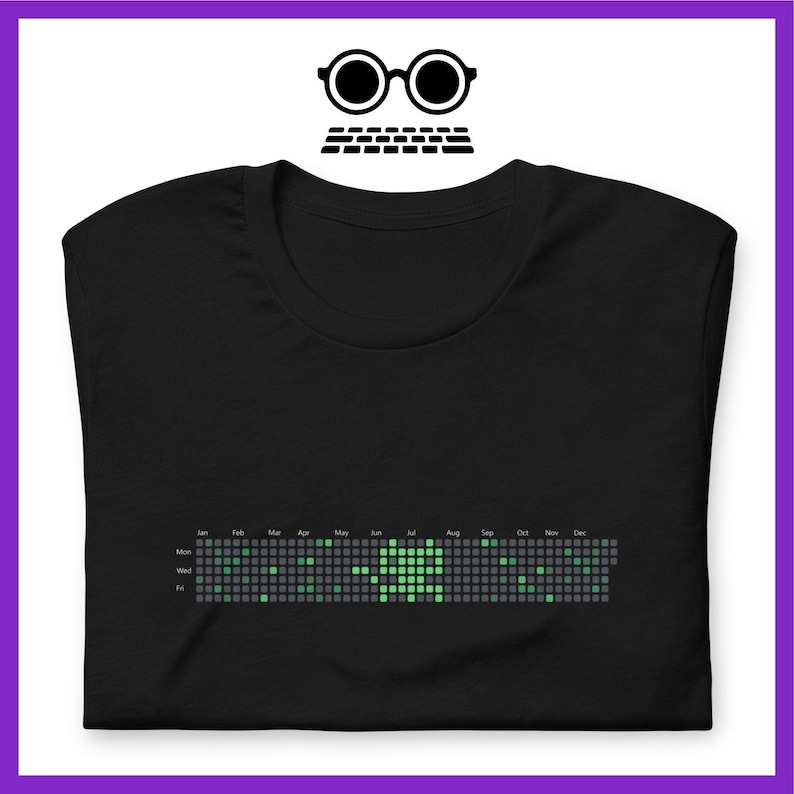 Peut inclure: T-shirt noir avec un motif de calendrier pixelis&eacute; vert. Le calendrier affiche les jours de la semaine et les mois de l'ann&eacute;e.