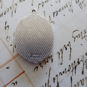 May include: Silver charm with a textured back and the word "ITALY" inscribed on the back.
