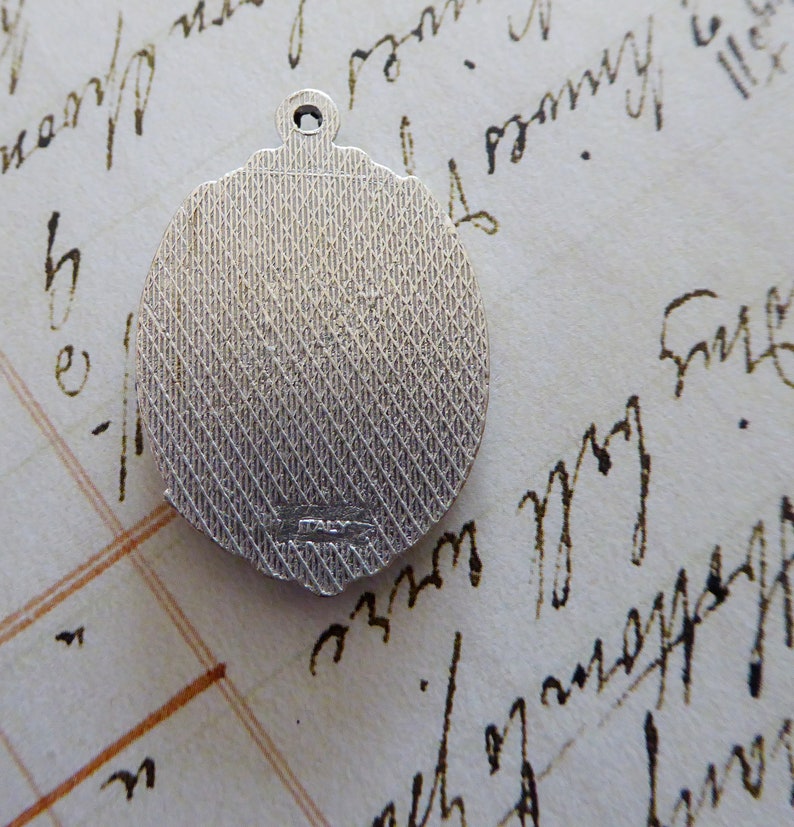 May include: Silver charm with a textured back and the word "ITALY" inscribed on the back.