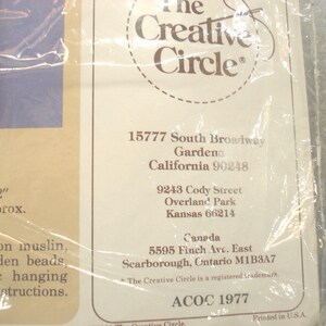 May include: A package with text that reads "The Creative Circle" and various addresses. The text also includes "11" x 12" towel approx." and "screened on muslin, rod, wooden beads, plastic hanging, and instructions."