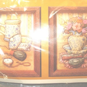 May include: Two framed prints with a vintage theme. One features a mug, soap dish, shaving brush, and pocket watch. The other shows a floral arrangement in a decorative pitcher and bowl, with a brush and comb.
