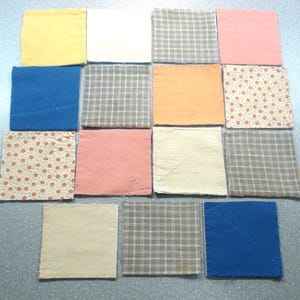 May include: A collection of sixteen square fabric swatches in various colors and patterns. Colors include yellow, white, blue, pink, orange, and beige. Patterns include plaid and floral designs. The swatches are arranged in a grid.