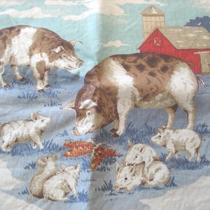 May include: Fabric with a farm scene featuring pigs, piglets, a red barn, and a silo. The pigs are brown and white, and the piglets are white. The background is a light blue with green grass.