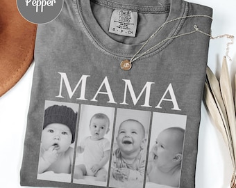 Op de afbeelding: Grijs Comfort Colors T-shirt met het woord "MAMA" in grote witte letters. Daaronder staan vier zwart-wit foto's van baby's. Een zilveren ketting met een hanger ligt op het shirt.