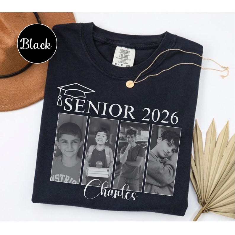 Puede incluir: Camiseta negra con el texto "SENIOR 2026" y un gr&aacute;fico de birrete. La camiseta presenta cuatro retratos en blanco y negro y el nombre "Charles" en cursiva. Un collar dorado est&aacute; sobre la camiseta.