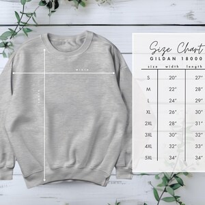 May include: A light gray Gildan 18000 sweatshirt with a size chart. The size chart shows the width and length measurements for sizes S through 5XL, ranging from 20 inches to 34 inches in width and 27 inches to 34 inches in length.