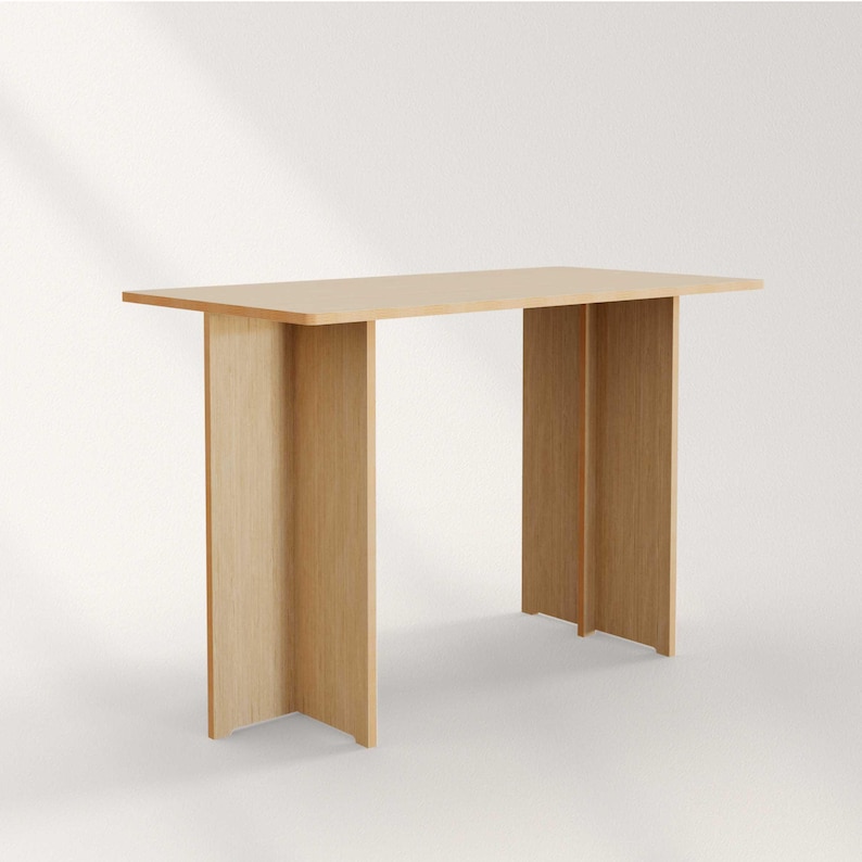 May include: A light-colored wooden console table with a rectangular top and two vertical supports. The table is made of light-colored wood and has a simple, modern design. The table is approximately 48 inches long.