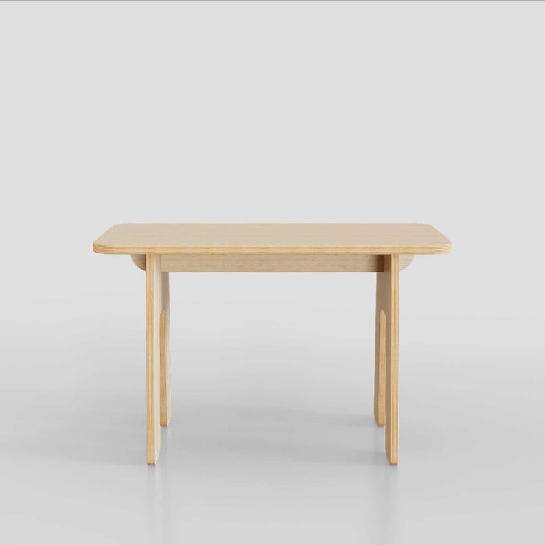 Puede incluir: Una mesa de madera clara con una tapa rectangular y cuatro patas. La mesa est&aacute; hecha de madera contrachapada y tiene un acabado de madera natural.