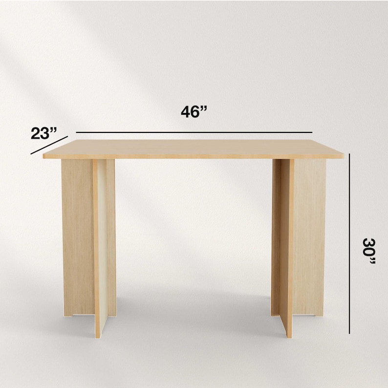 May include: A light-colored wooden table with a rectangular top and two supporting legs. The table is 46 inches long, 23 inches wide, and 30 inches high.
