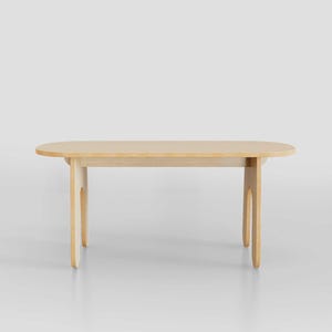 Puede incluir: Una mesa ovalada de madera clara con un dise&ntilde;o sencillo. La mesa tiene cuatro patas con forma de arcos.