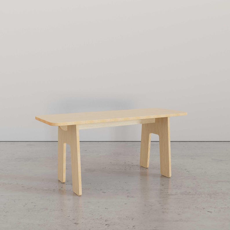 Puede incluir: Una mesa de madera clara con un dise&ntilde;o sencillo. La mesa tiene una tapa rectangular y cuatro patas. Las patas est&aacute;n hechas de una sola pieza de madera que se dobla para formar una forma como una U invertida.
