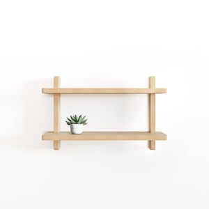 May include: A two-tiered wooden shelf with a small potted succulent plant on the top shelf.