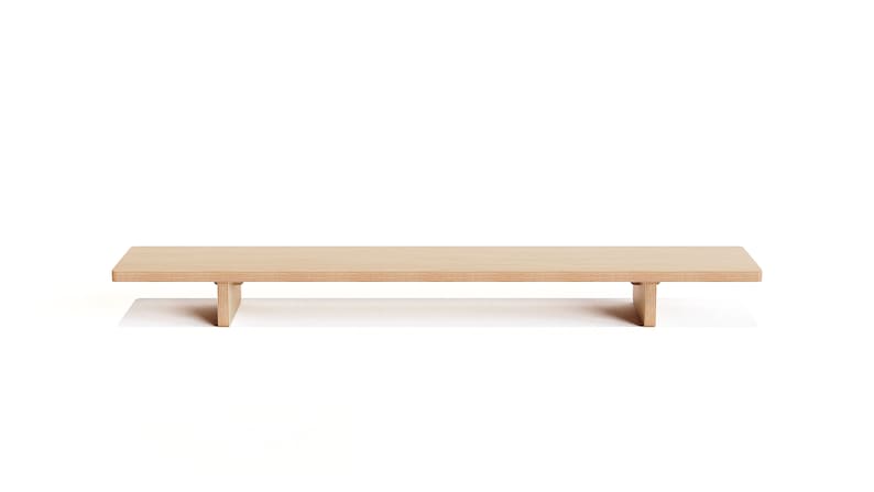 May include: A long, rectangular wooden shelf with two short legs on each end. The shelf is made of light brown wood and is sitting on a white surface.