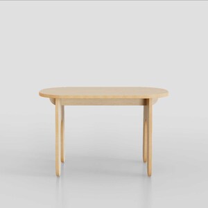 Puede incluir: Una mesa ovalada de madera clara con bordes redondeados y cuatro patas. La mesa est&aacute; hecha de madera clara y tiene un acabado natural.