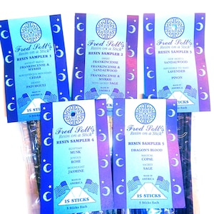 May include: Multiple packs of Fred Soll's Resin on a Stick incense samplers. Each pack is blue and features the brand name, sampler number, and scent descriptions like Dragon's Blood, Frankincense, and Myrrh. Each pack contains 15 sticks.