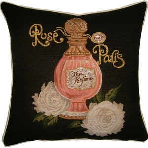 May include: A black and white pillow with a gold embroidered design of a perfume bottle and roses. The bottle is labeled "Rose Perfume" and the text "Rose Paris" is embroidered on the pillow.
