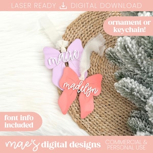 Puede incluir: Dos adornos en forma de lazo, uno lila claro y otro coral, con los nombres "mae" y "madelyn" en escritura blanca. Los adornos tienen cintas blancas para colgar. El texto en la imagen incluye "¡adorno o llavero!" y "mae's digital designs."